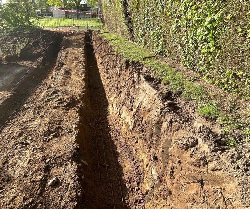Fouilles en rigole avec les armatures de fondation posées au fond