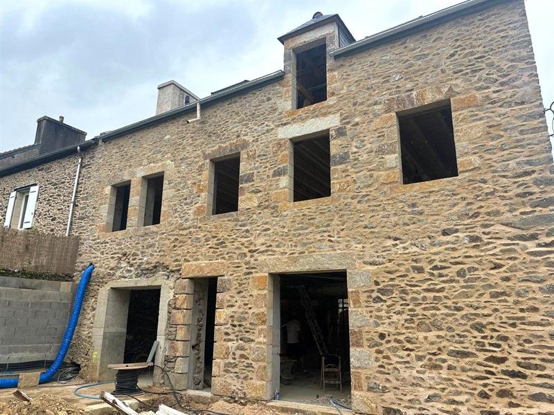 Façade de maison en pierre rénovée, avec des ouvertures encadrées de pierre de taille